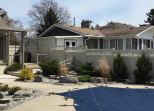 Tan vinyl privacy fence with lattice top installed around a landscaped backyard and pool in North Pelham and Fenwick, Niagara.